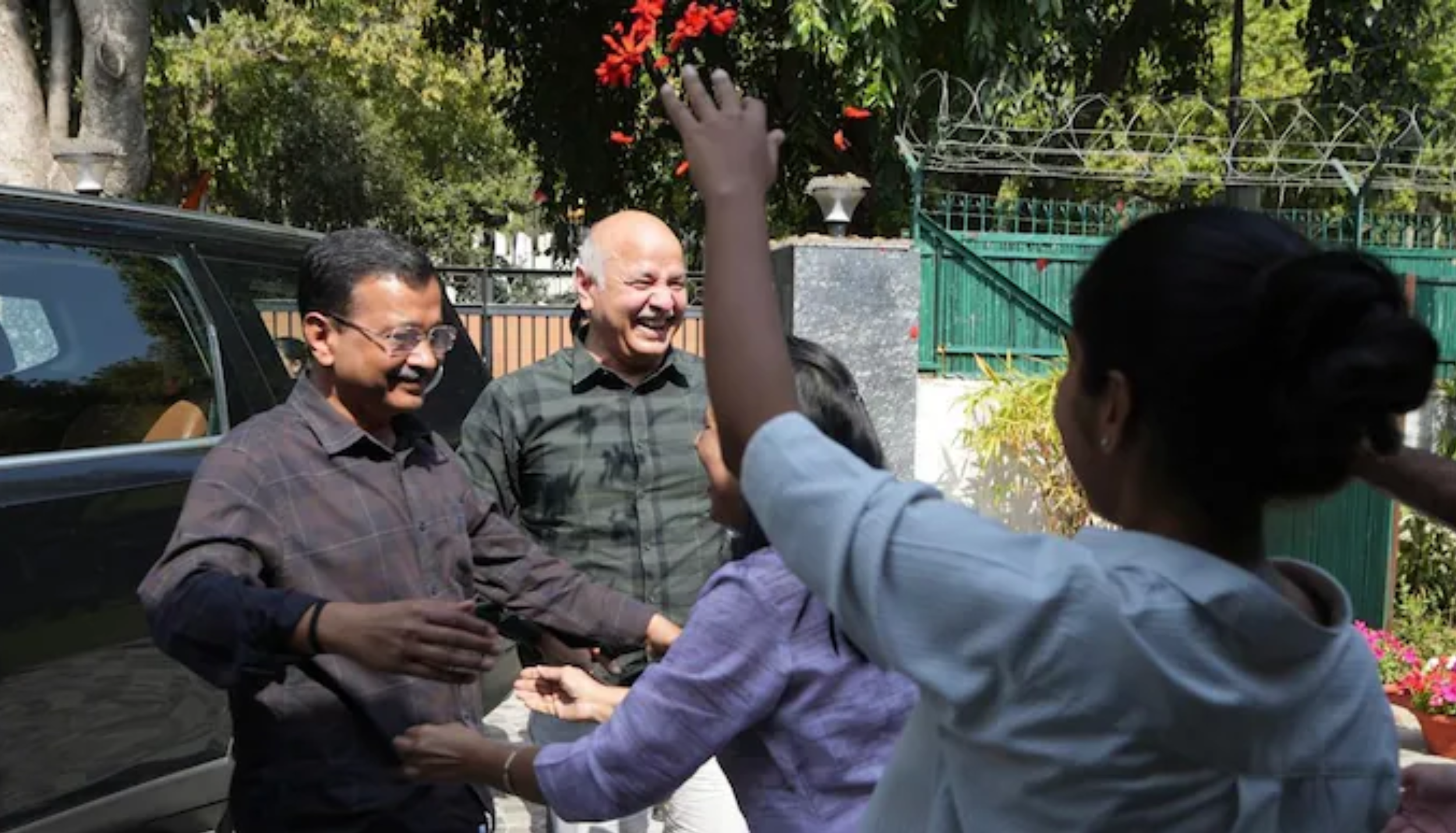 Arvind Kejriwal and Manish Sisodia greeting supporters outside a residence