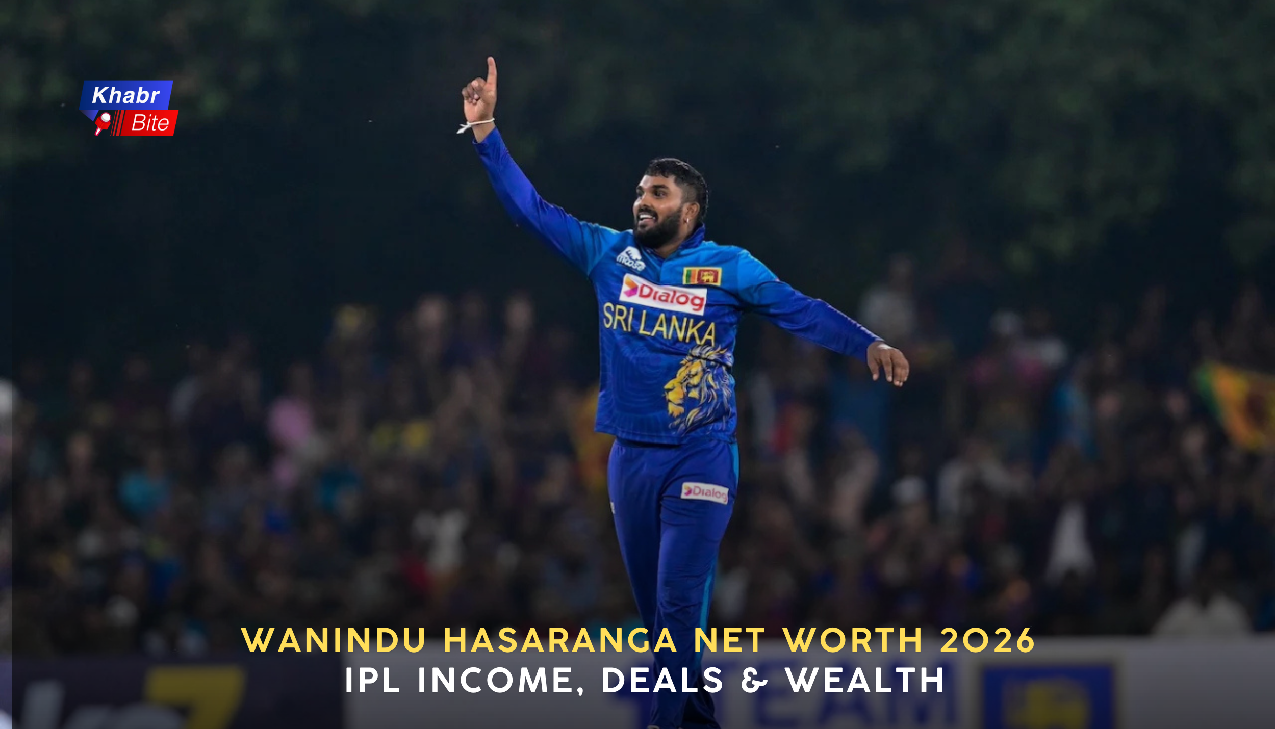 Wanindu Hasaranga celebrating a wicket for Sri Lanka, pointing upward during a night cricket match while wearing the blue Sri Lanka jersey.