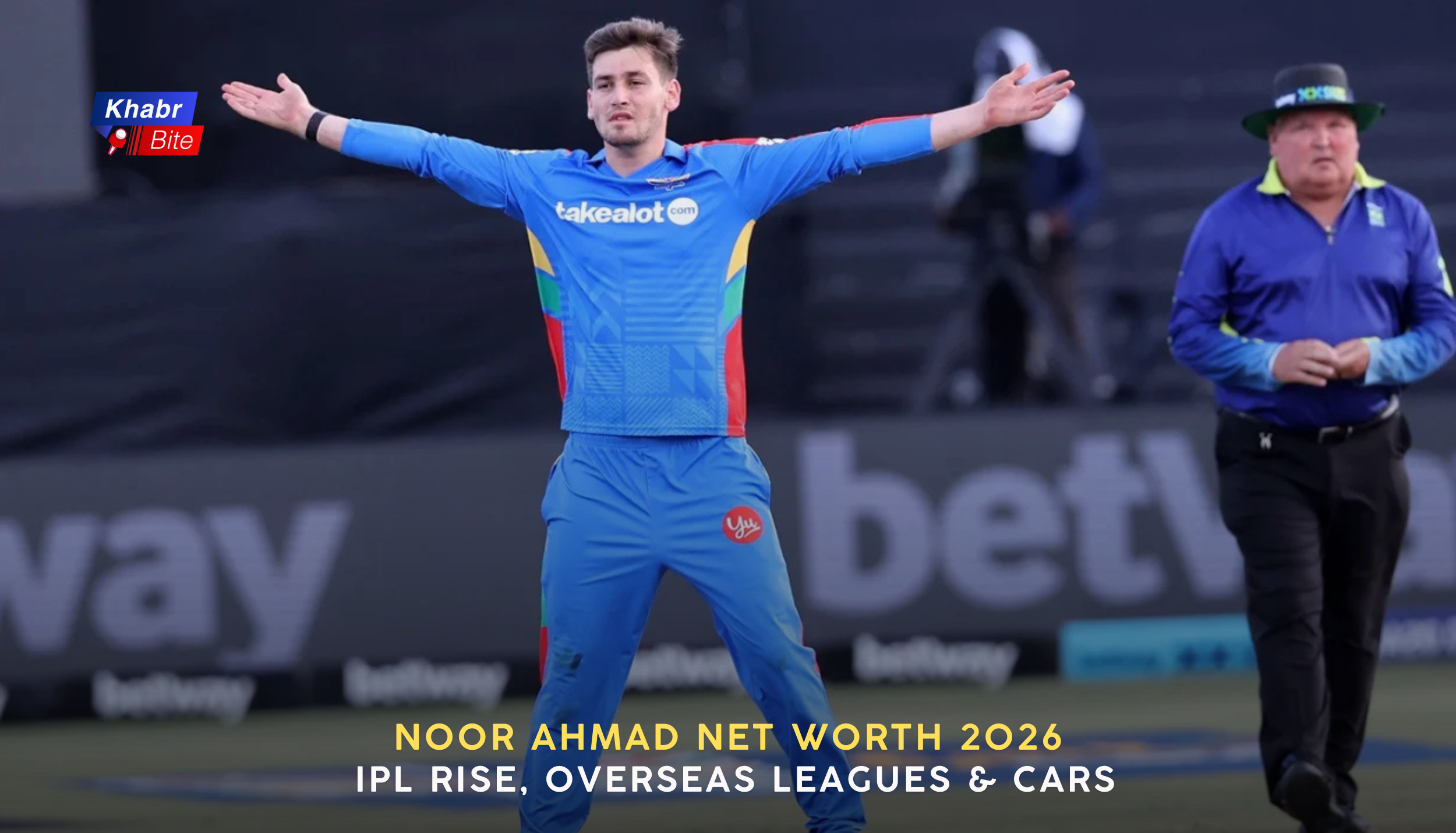 Noor Ahmad celebrating a wicket for Afghanistan with arms outstretched, wearing blue national team jersey during an international cricket match, umpire visible in background