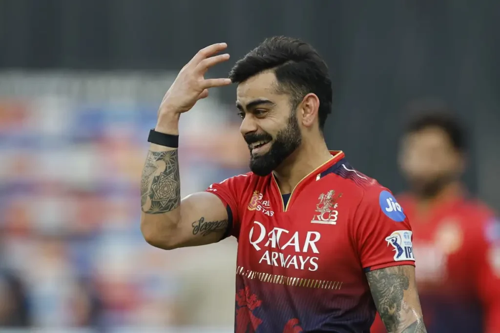 Virat Kohli smiling in RCB jersey during IPL match celebration