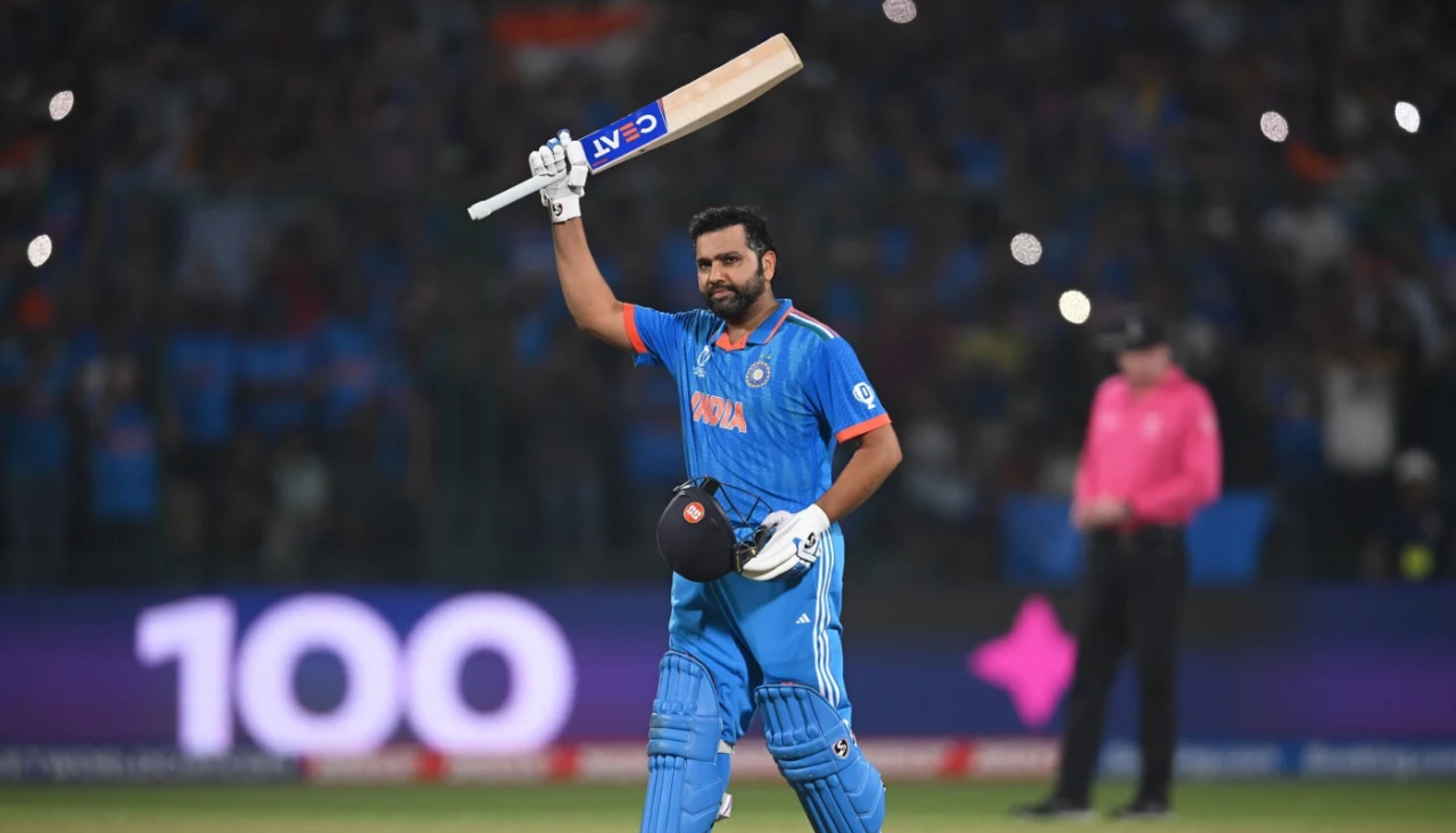 Indian cricketer Rohit Sharma raising his bat after scoring a century during a match